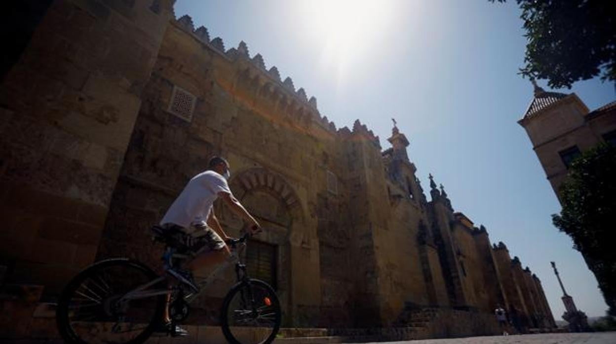 Un joven pasea en bicicleta junto a la Mezquita-Catedral