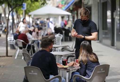 Un camarero atiende una mesa en la avenida de Barcelona