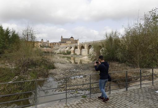 Un joven haciéndole fotos al río junto al Puente Romano