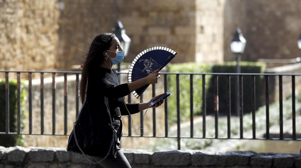 Una joven se abanica junto a la Puerta de Almodóvar