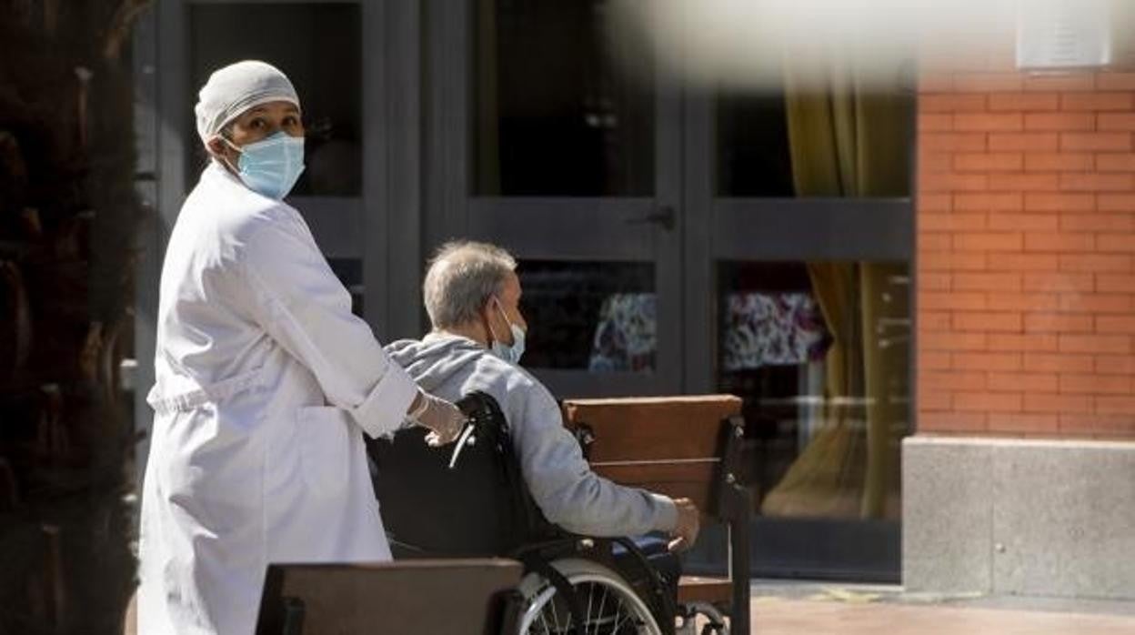 Un residente de un centro de mayores atendido por una cuidadora