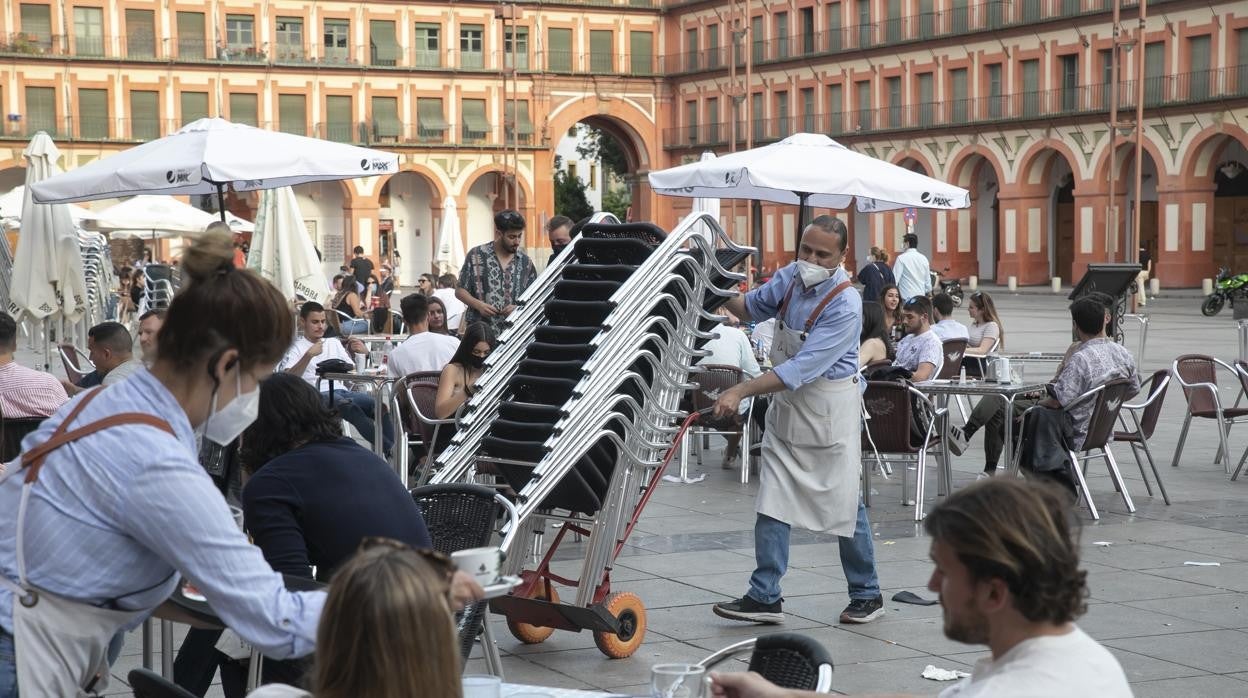 Un camarero retira sillas en la plaza de La Corredera