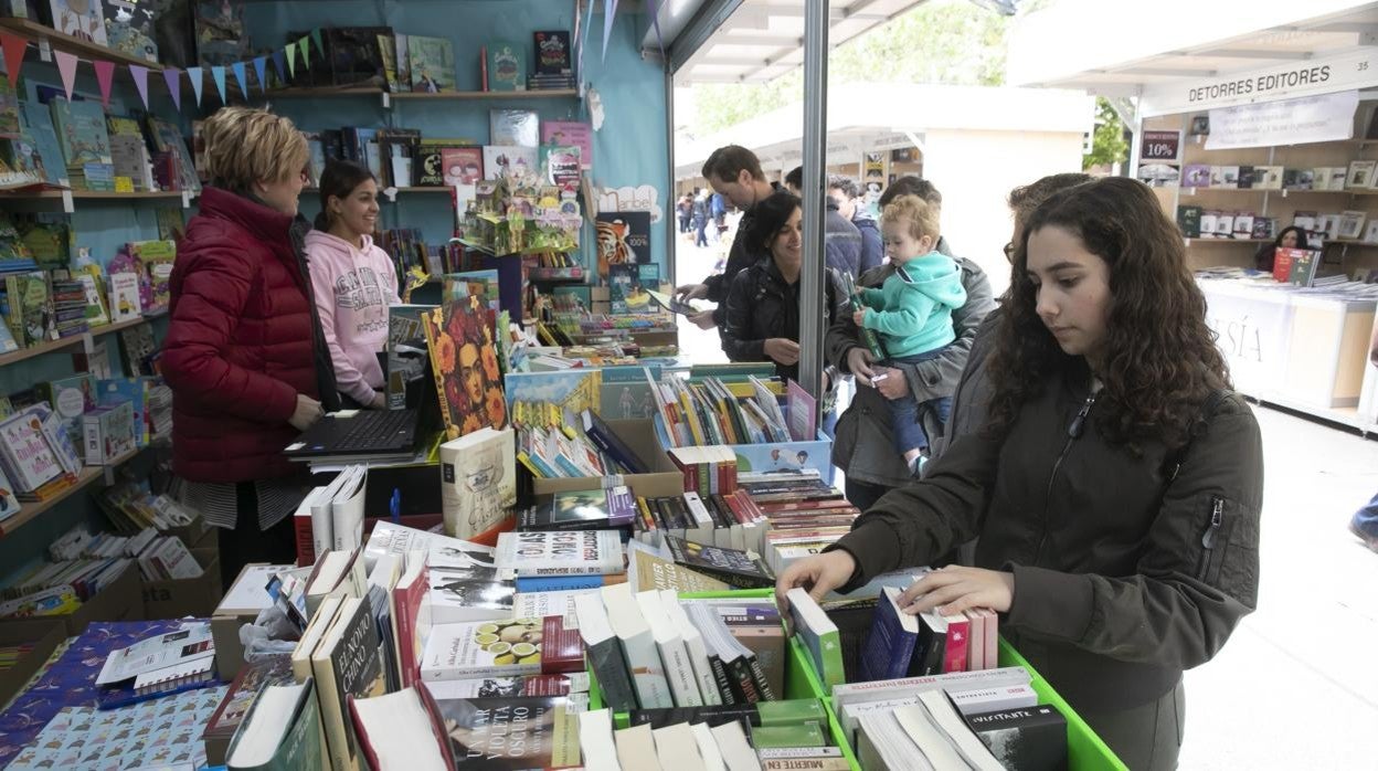 Una joven pasa por un puesto en la Feria del Libro de Córdoba