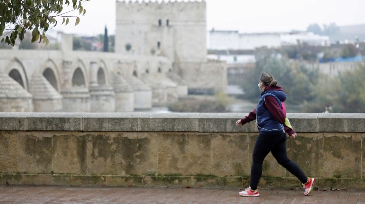 Una mujer camina por la Ribera en una mañana gris