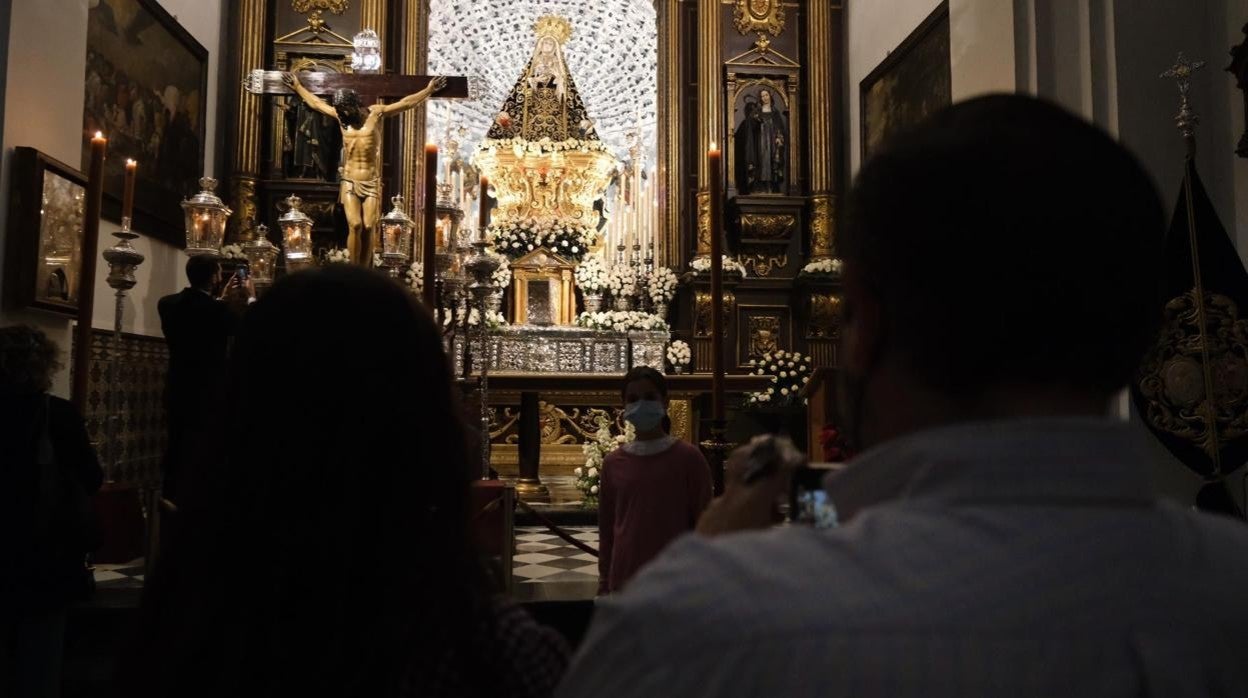 Una familia reza ante el Cristo de la Clemencia y la Virgen de los Dolores, el Viernes Santo de 2021