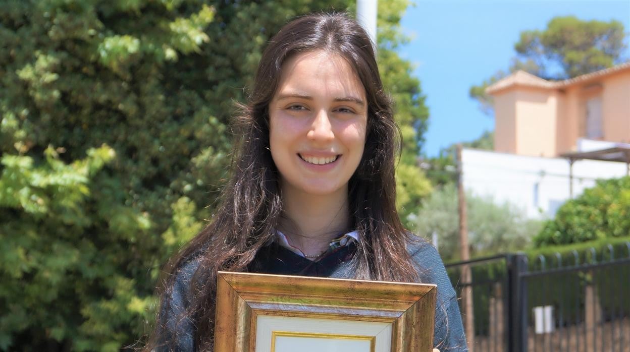 La alumna premiada posa con la distinción.