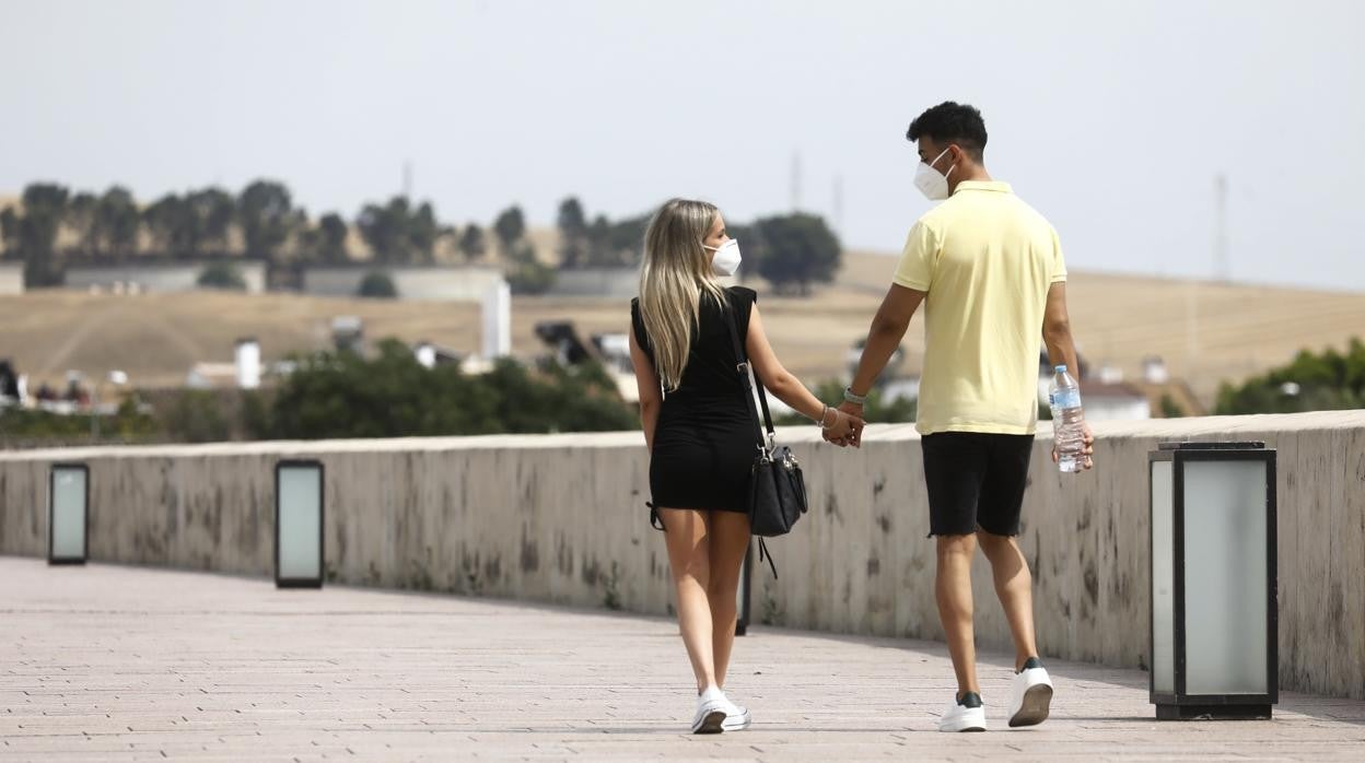 Una pareja pasea por el Puente Romano de Córdoba