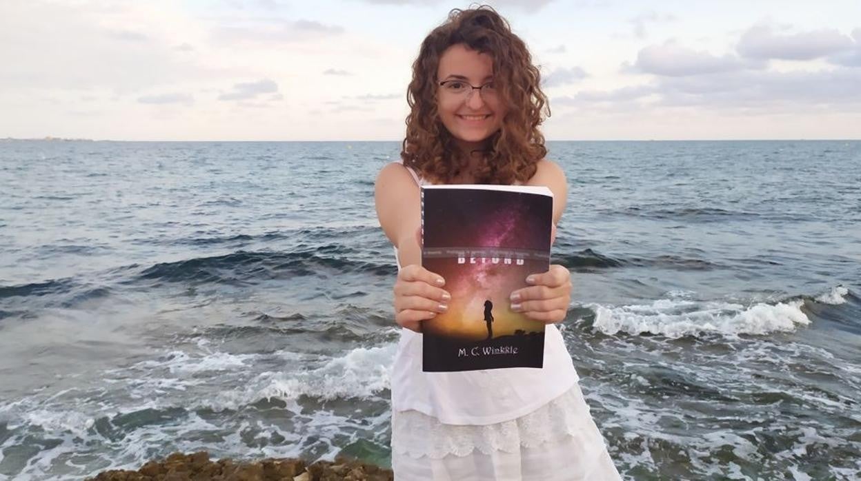 María Cuadrado posa junto al mar con su primera novela