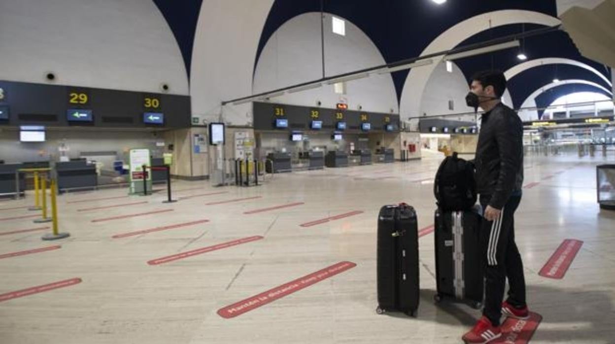 Un joven con mascarilla en el aeropuerto de Sevilla