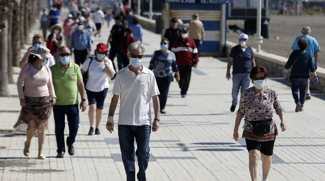 Malagueños pasean con mascarilla por el Paseo Marítimo Pablo Ruiz Picasso