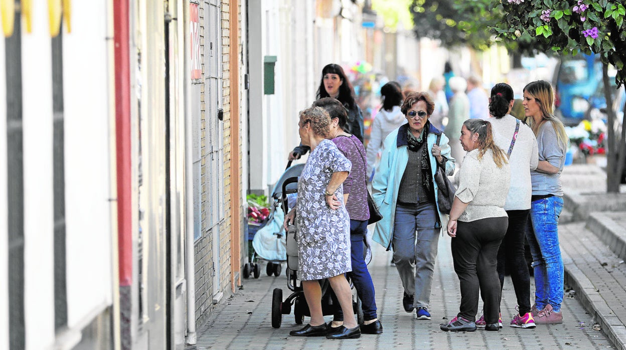 Varias mujeres pasean por una callen de Alcolea, barrio periférico de la capital