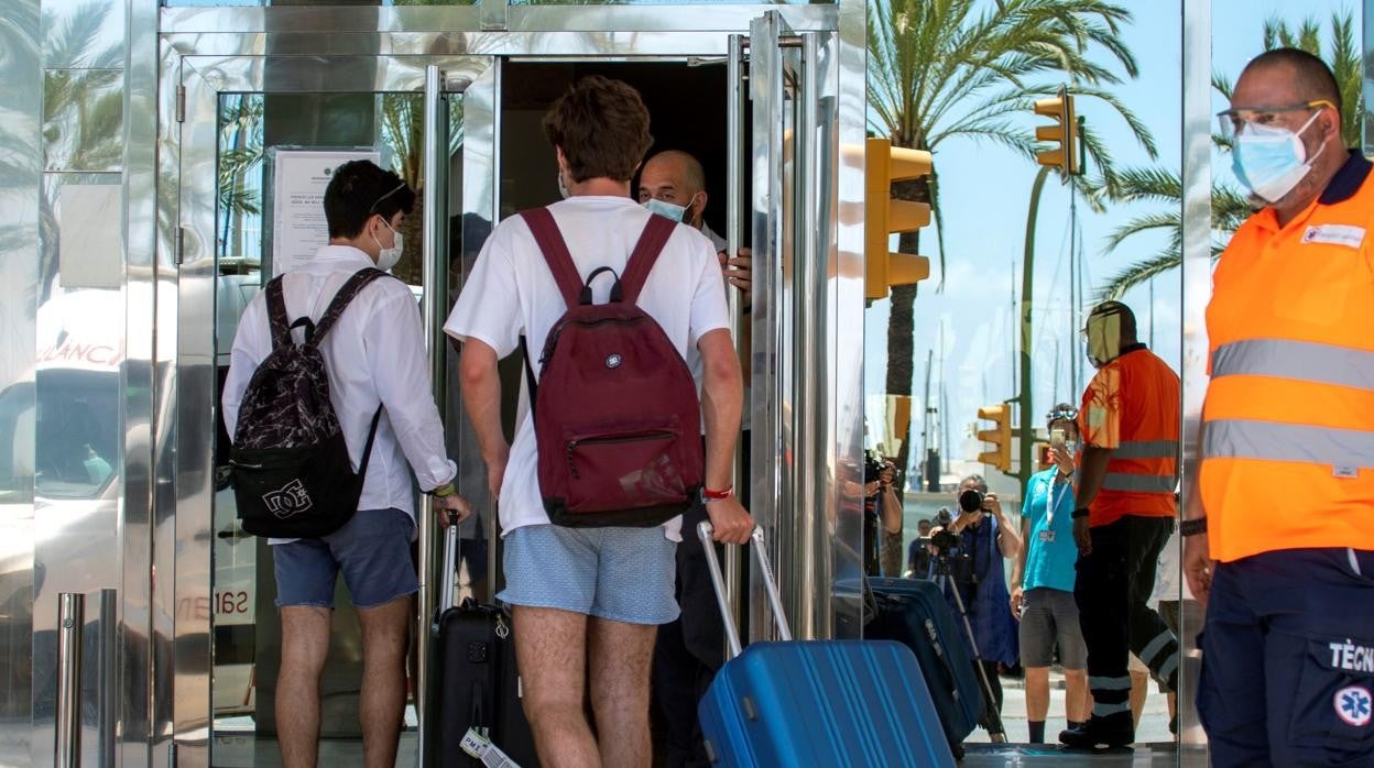 Jóvenes entrando en el hotel Palma Bellver para su confinamiento obligatorio