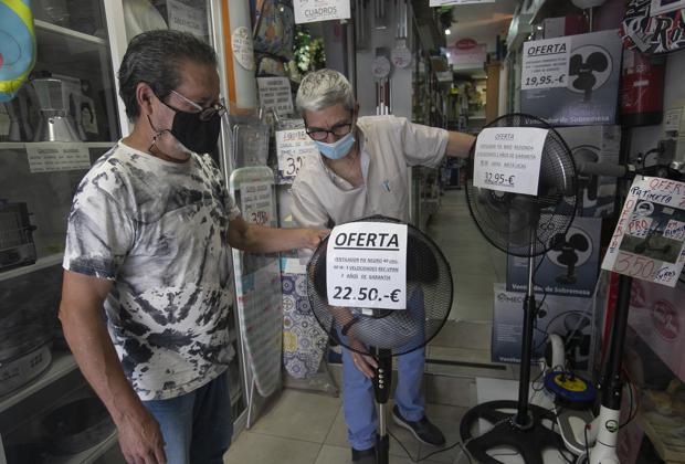 Un vecino del Sector Sur comprueba un ventilador en un comercio del barrio