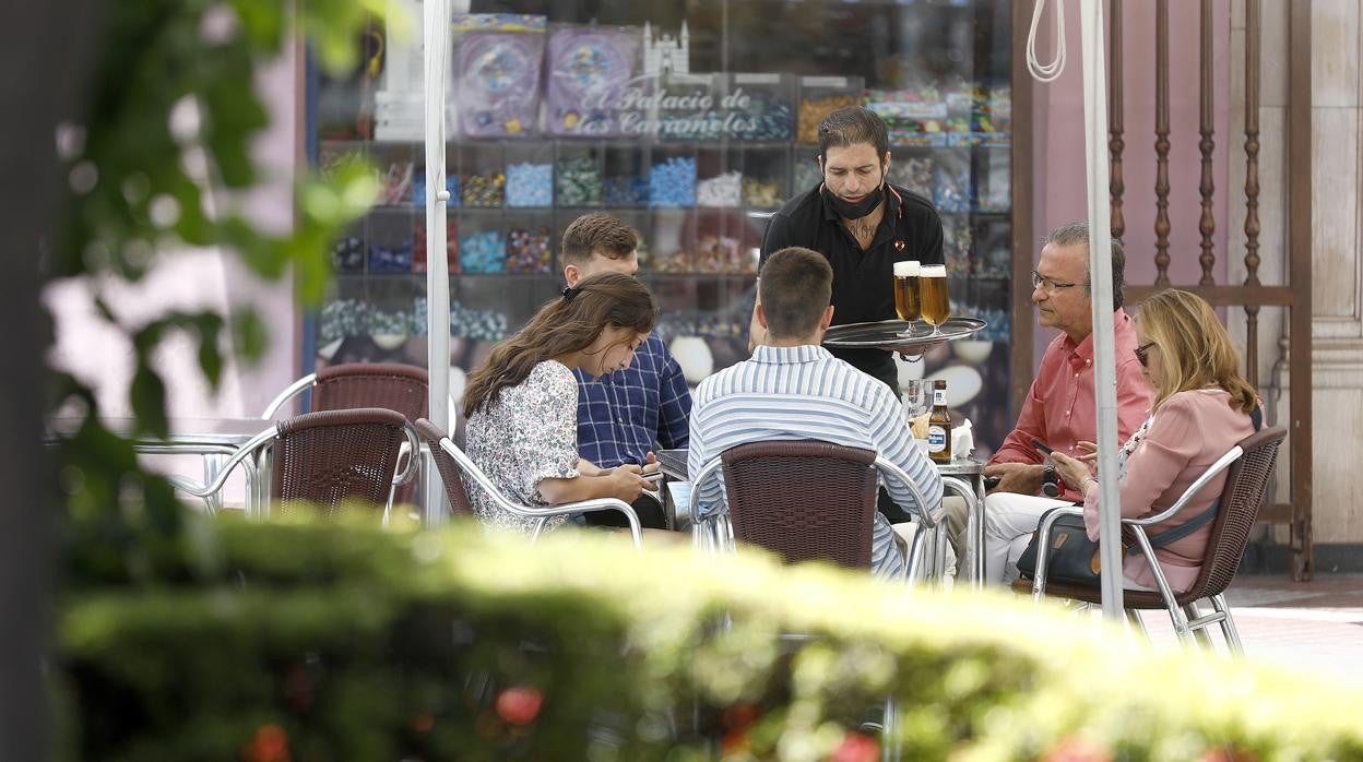 Un camarero atiende una terraza de Córdoba a finales de junio de este año