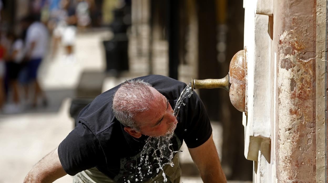 Un hombre se refresca en el Patio de los Naranjos de la Mezquita-Catedral de Córdoba