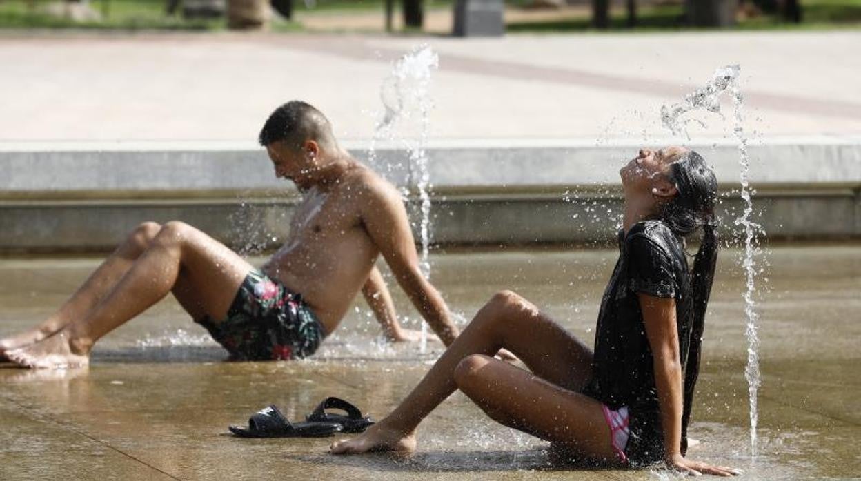 Dos jóvenes se refrescan en el Vial en la tarde de ayer en la capital cordobesa