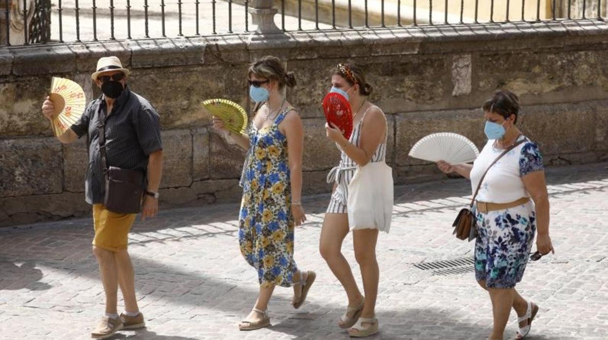 Unos paseantes con el abanico en la mano en Córdoba esta semana