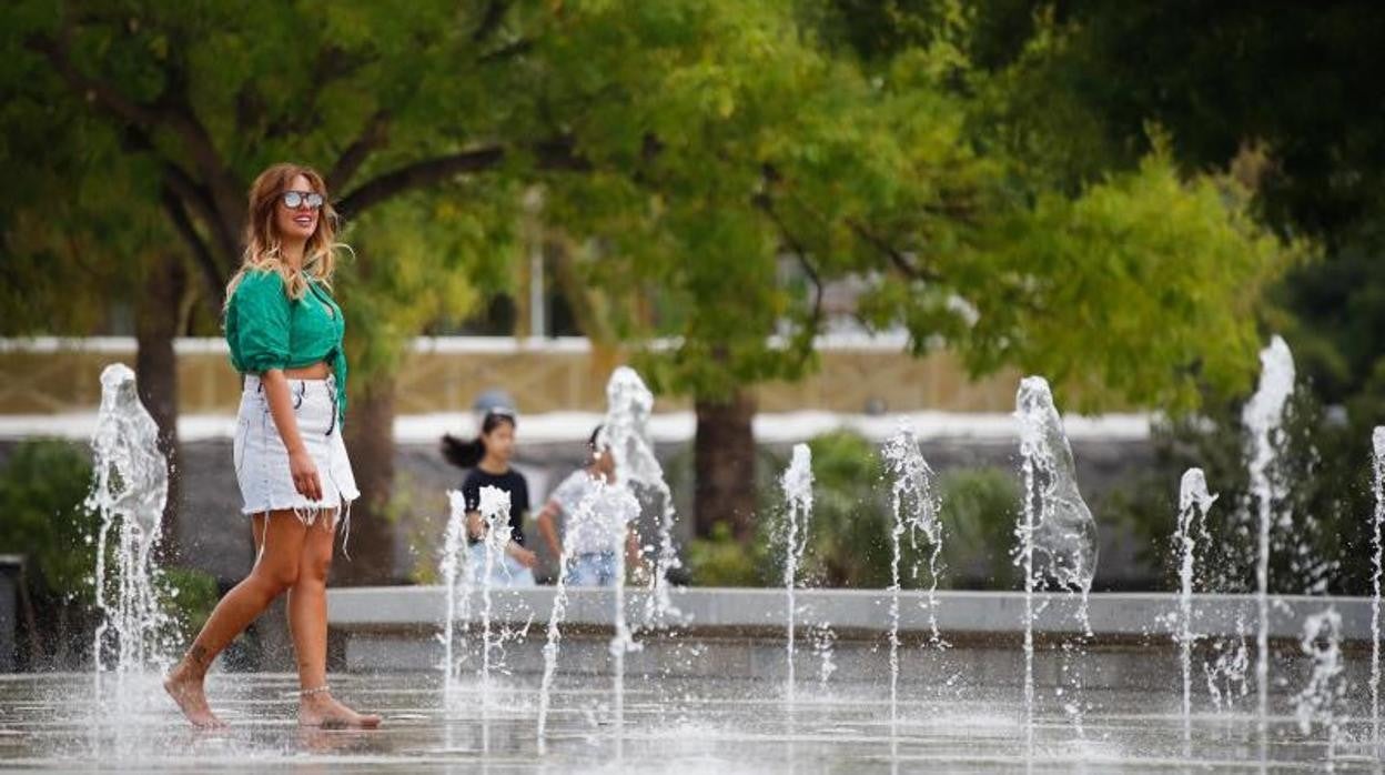 Una joven se refresca en una fuente de la capital cordobesa