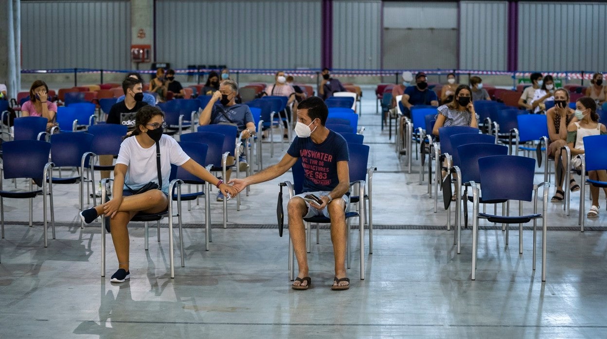 Padre e hija esperan a ser vacunados en el Palacio de Ferias y Congresos de Málaga