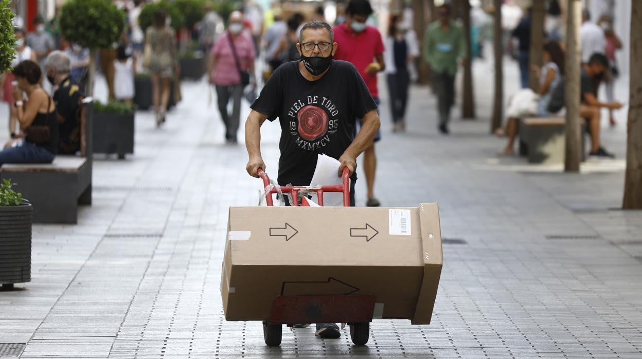 Un hombre transporta mercancía por la calle Cruz Conde