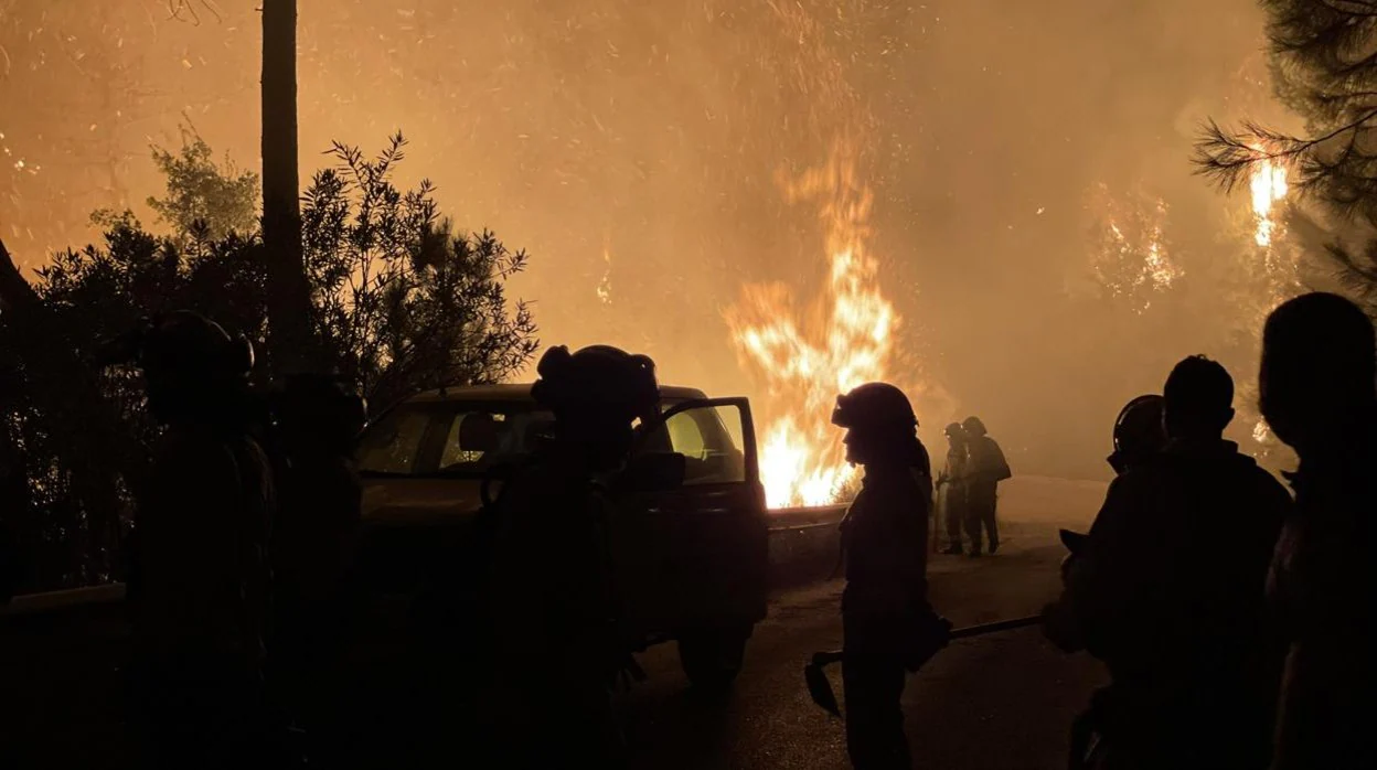 Bomberos enfrentandose al fuego durante la noche