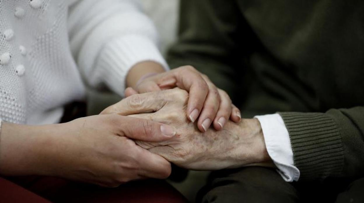 Una mujer sostiene la mano de un familiar enfermo en febrero de este año en Córdoba