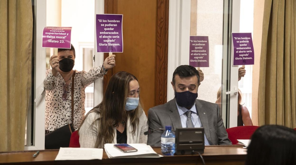 Los concejales de Vox en el Pleno del Ayuntamiento de Córdoba con protestas a sus espaldas