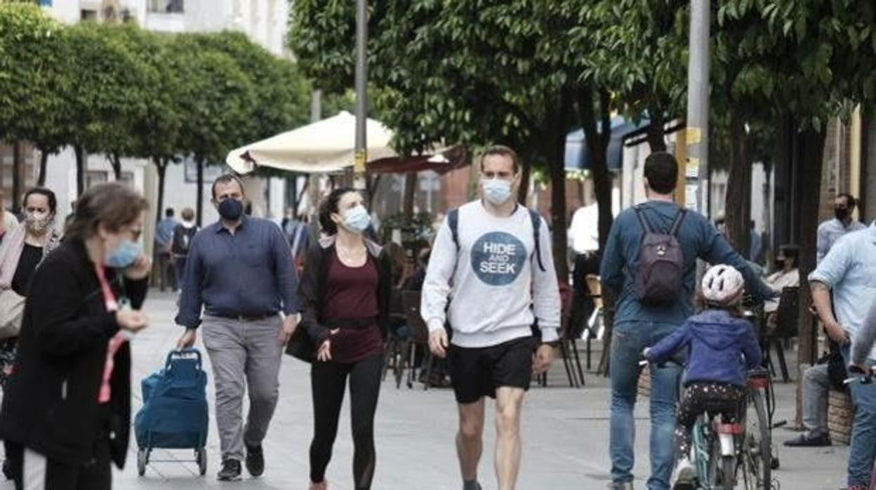 Ciudadanos pasean por la calle con la mascarilla puesta