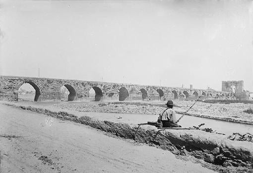 Un hombre pesca en el Guadalquivir, en una imagen de 1896