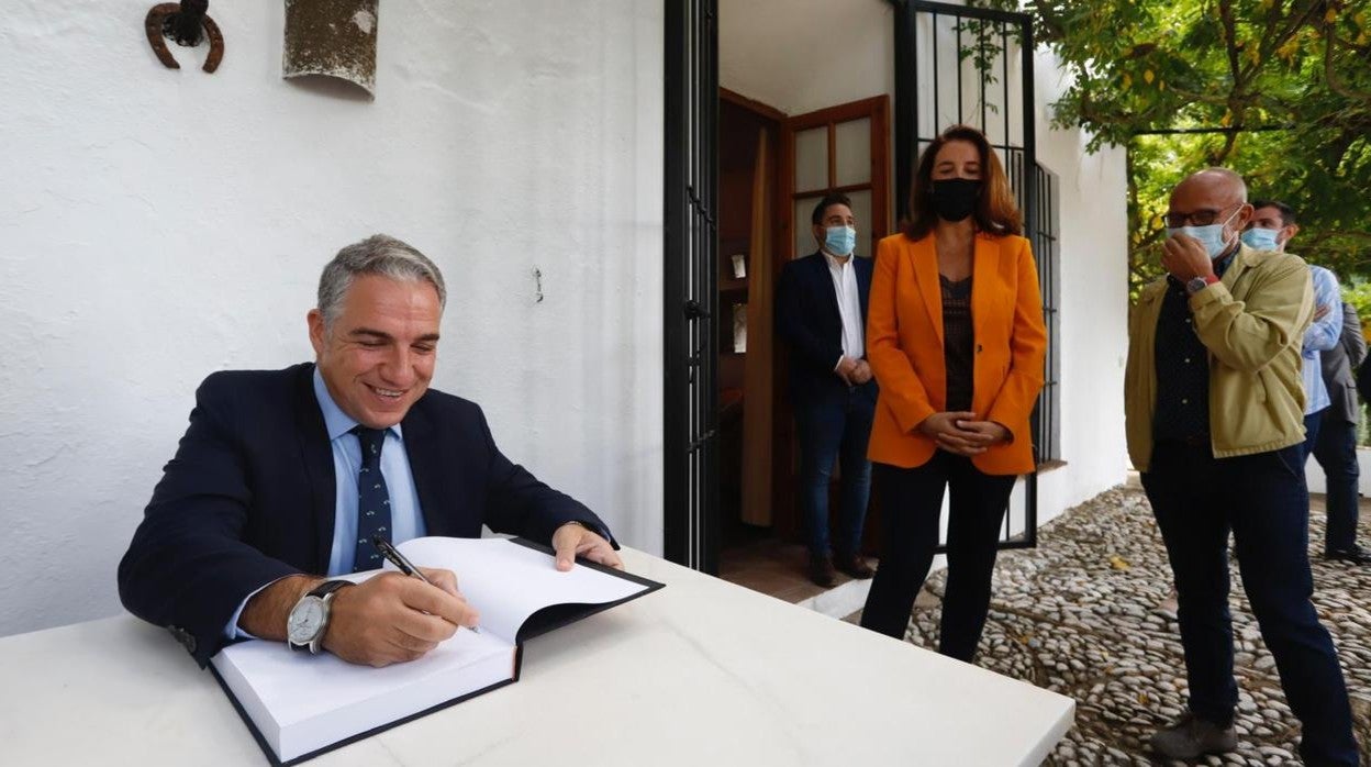 El consejero Elías Bendodo firma en el libro de visitas de la Finca La Baltasara en Málaga