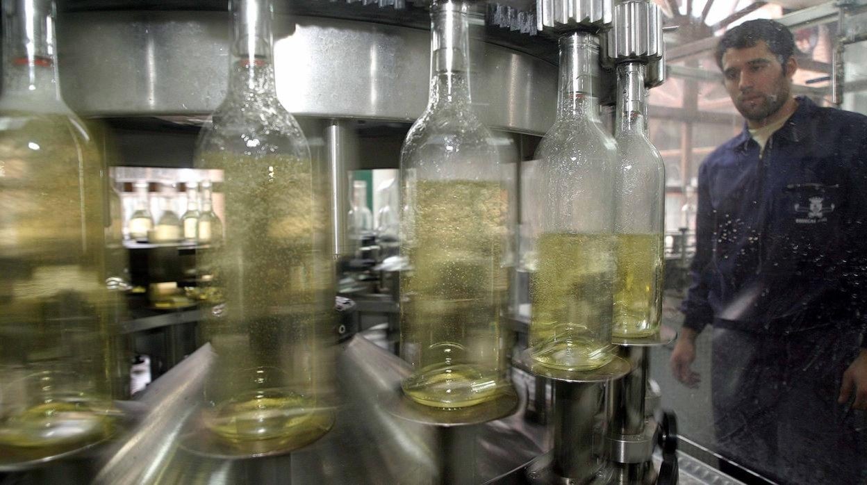 Un operario en una planta de embotellado de vinos