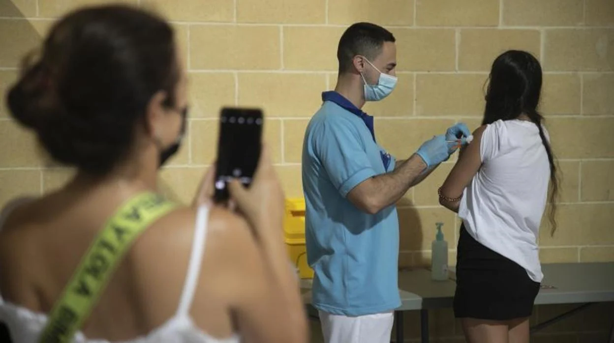 Una joven es fotografiada cuando se pone la vacuna contra el Covid en Córdoba