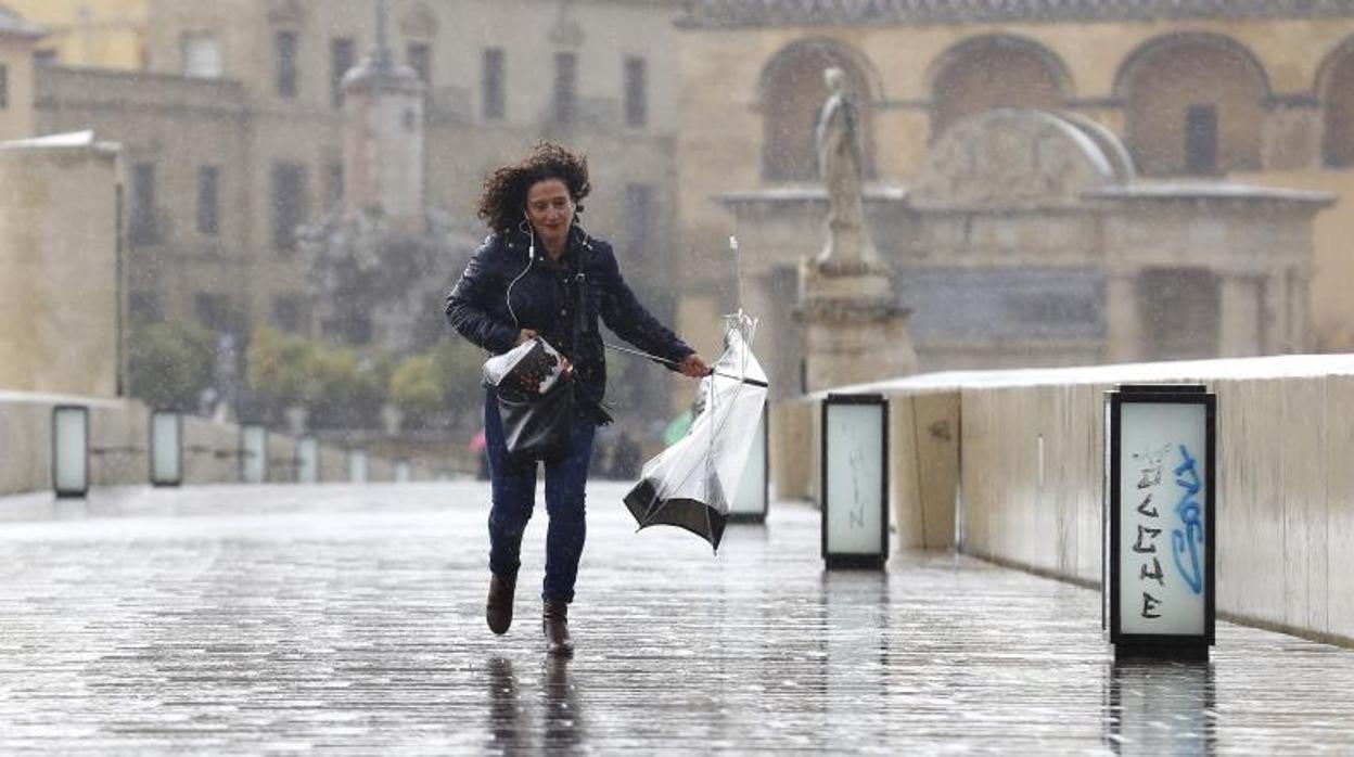 Una mujer con la lluvia en el Puente Romano de Córdoba