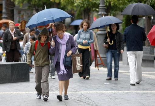 Cordobeses por las calles de la ciudad abrigados y con paraguas