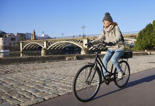 Una señora pasea en bicicleta por Sevilla