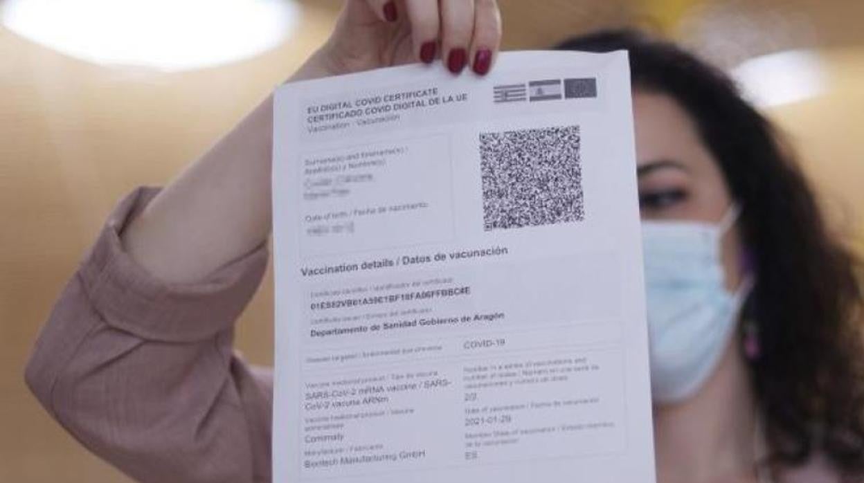 Una joven muestra su certificado de vacunación Covid