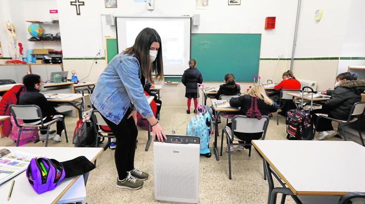 Una profesora enciende un calefactor con filtro de aire en un colegio de Córdoba en una imagen de archivo