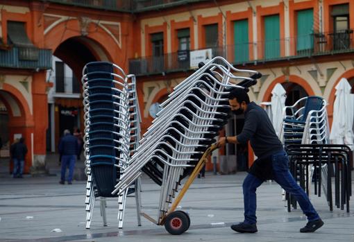 Un trabajador de un negocio de hostelería de La Corredera prepara una terraza