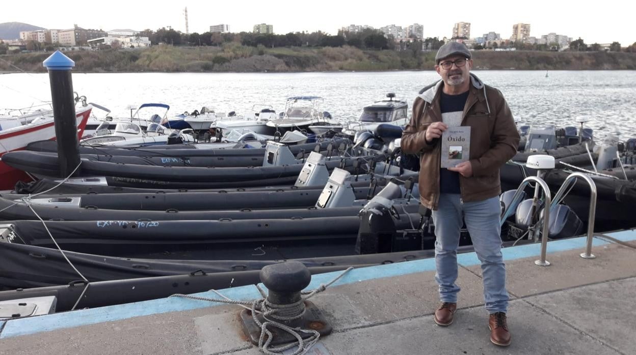 Julio Verdú con su libro, junto a narcolanchas intervenidas en el Campo de Gibraltar