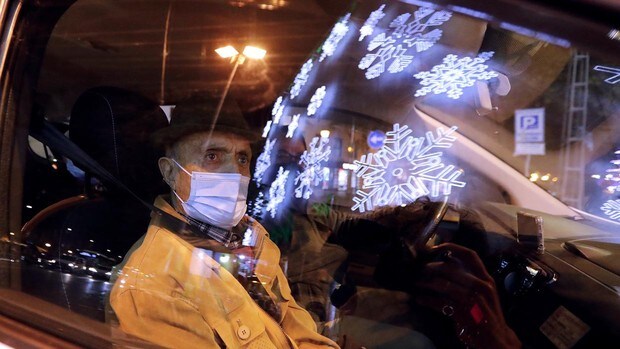 La ilusión de los mayores por la Navidad a través del reflejo del cristal de los taxis de Córdoba