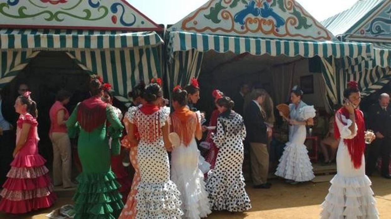 Flamencas a la puerta de una caseta en la Feria de Sevilla