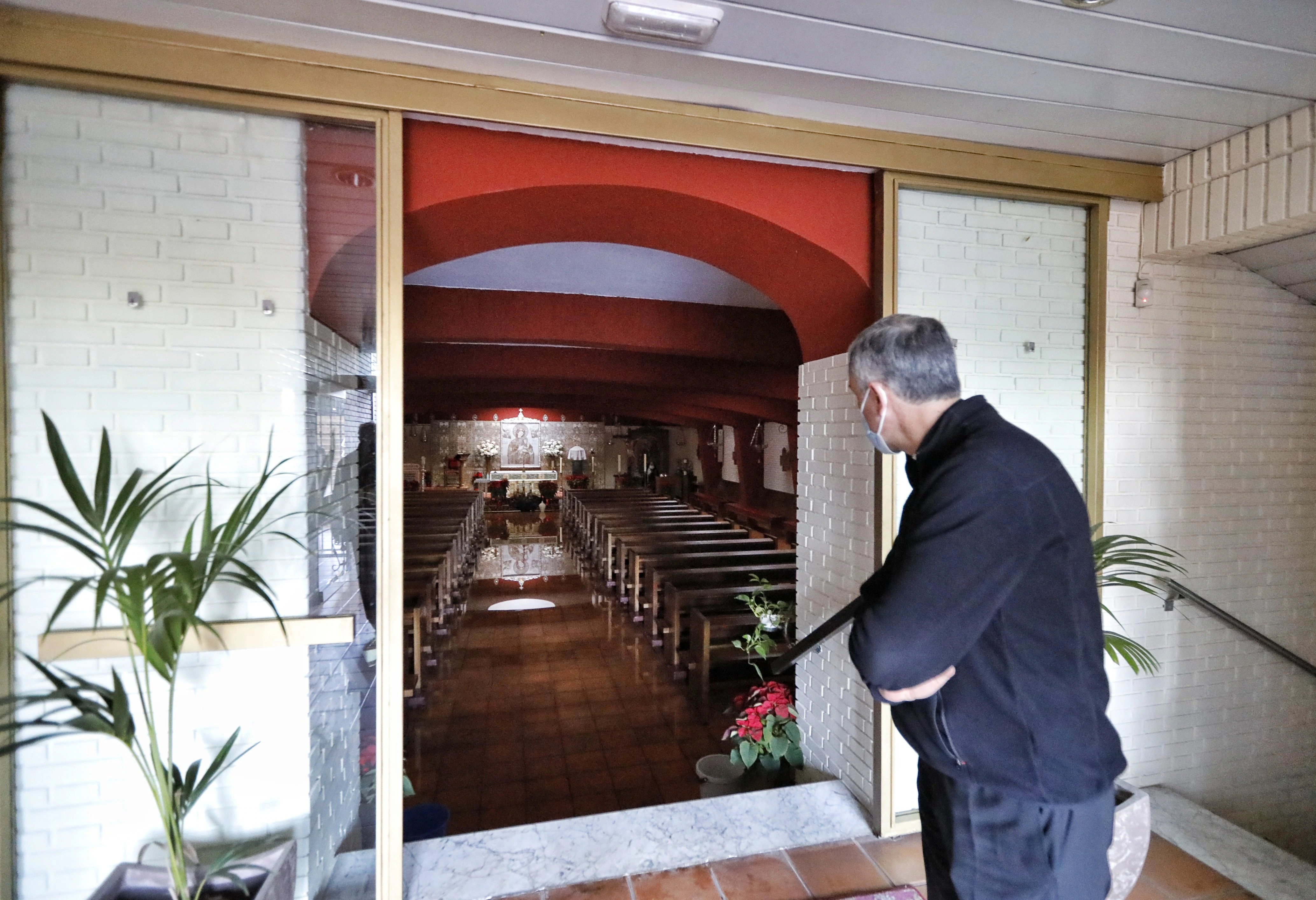 Un sacerdote mira hacia el interior del edificio religioso