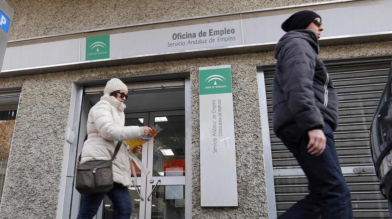 Dos personas pasan frente a una oficina de empleo del SAE en Córdoba