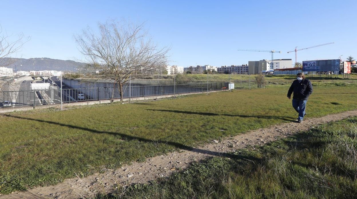 Un hombre pasa delante de parte de los suelos que ocupará el futuro parque 'Poniente-Miralbaida'