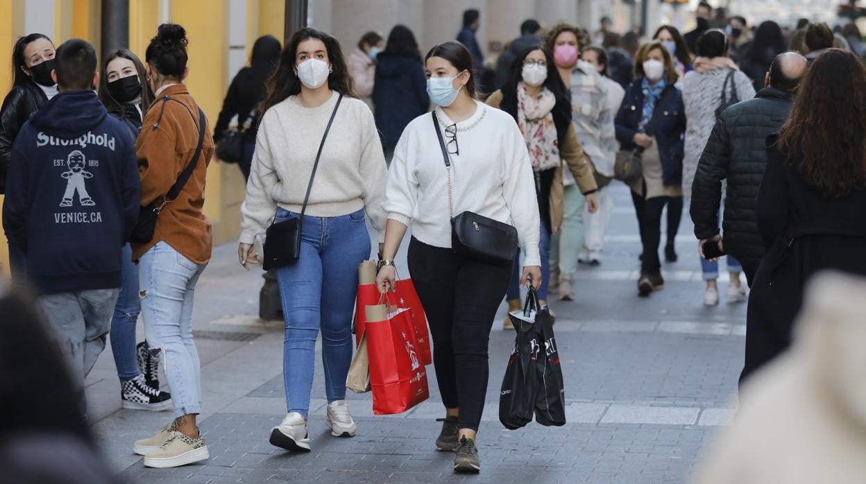 Una pareja de jóvenes, de compras, pasando por la calle Gondomar