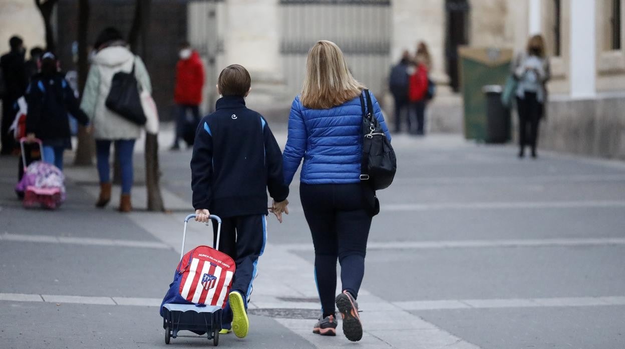 Un niño con una mujer camino del colegio en el Centro de Córdoba