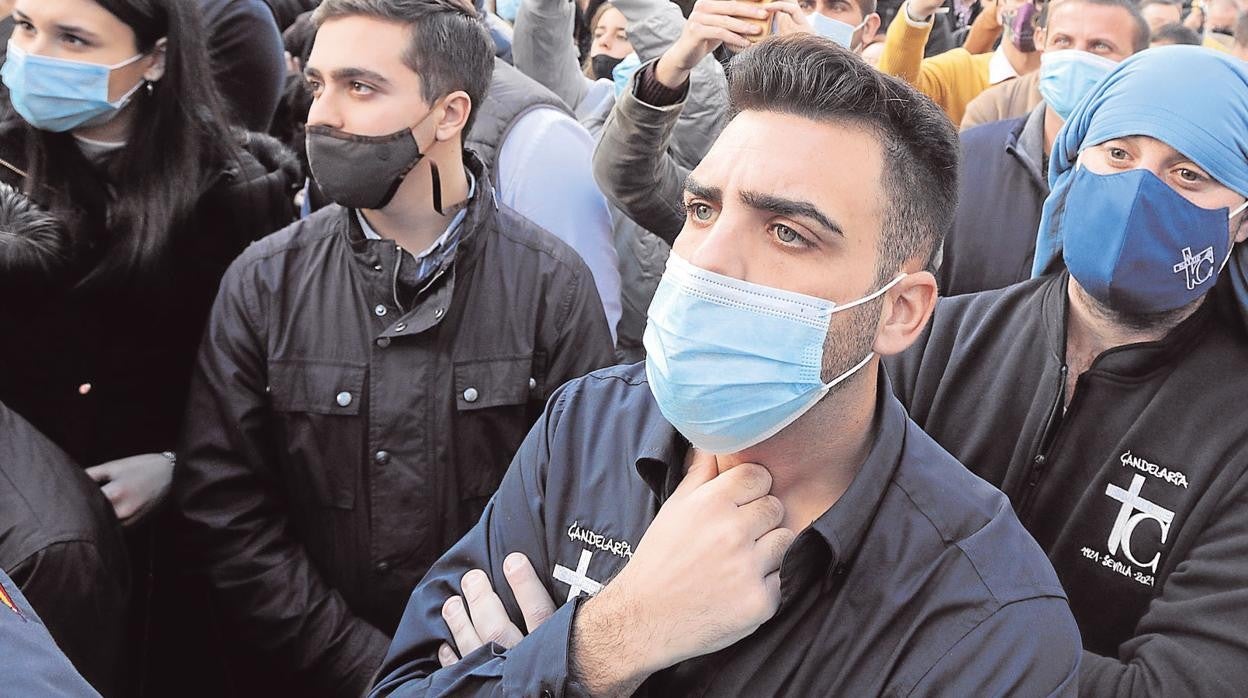 Costaleros y sevillanos en la salida de La Candelaria, en Sevilla