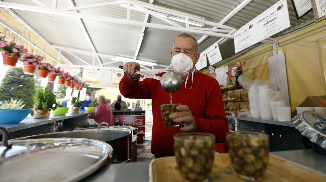 Un hombre sirve una ración de caracoles