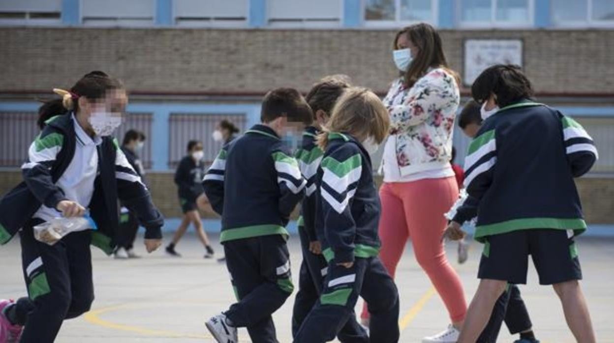 Niños con mascarilla en el patio del colegio