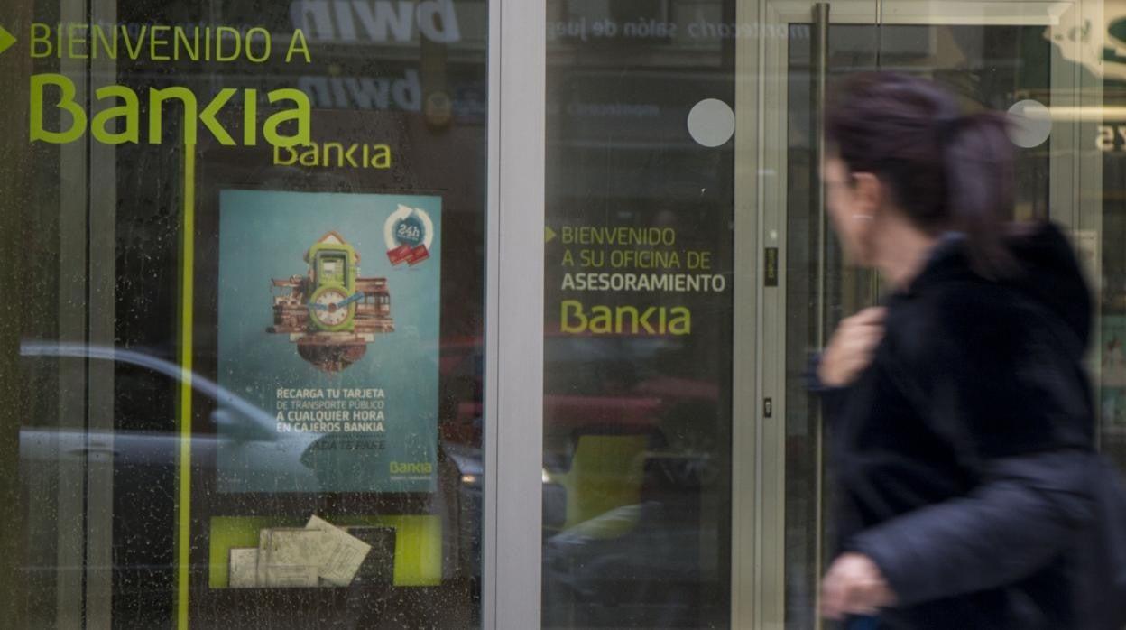 Una mujer pasa delante de una oficina de Bankia